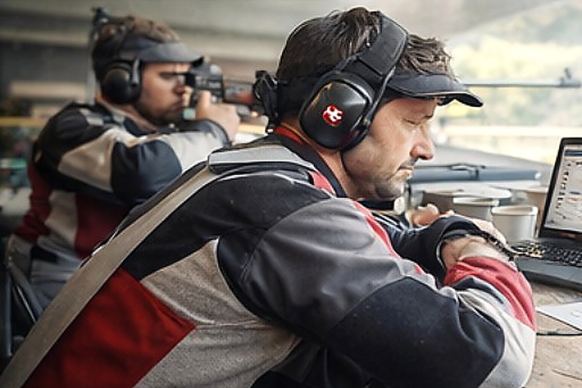 Schütze mit Laptop und Resultatübersicht im Schützenhaus